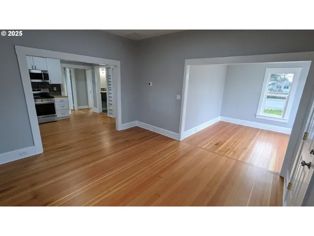 a room with wooden floor and windows