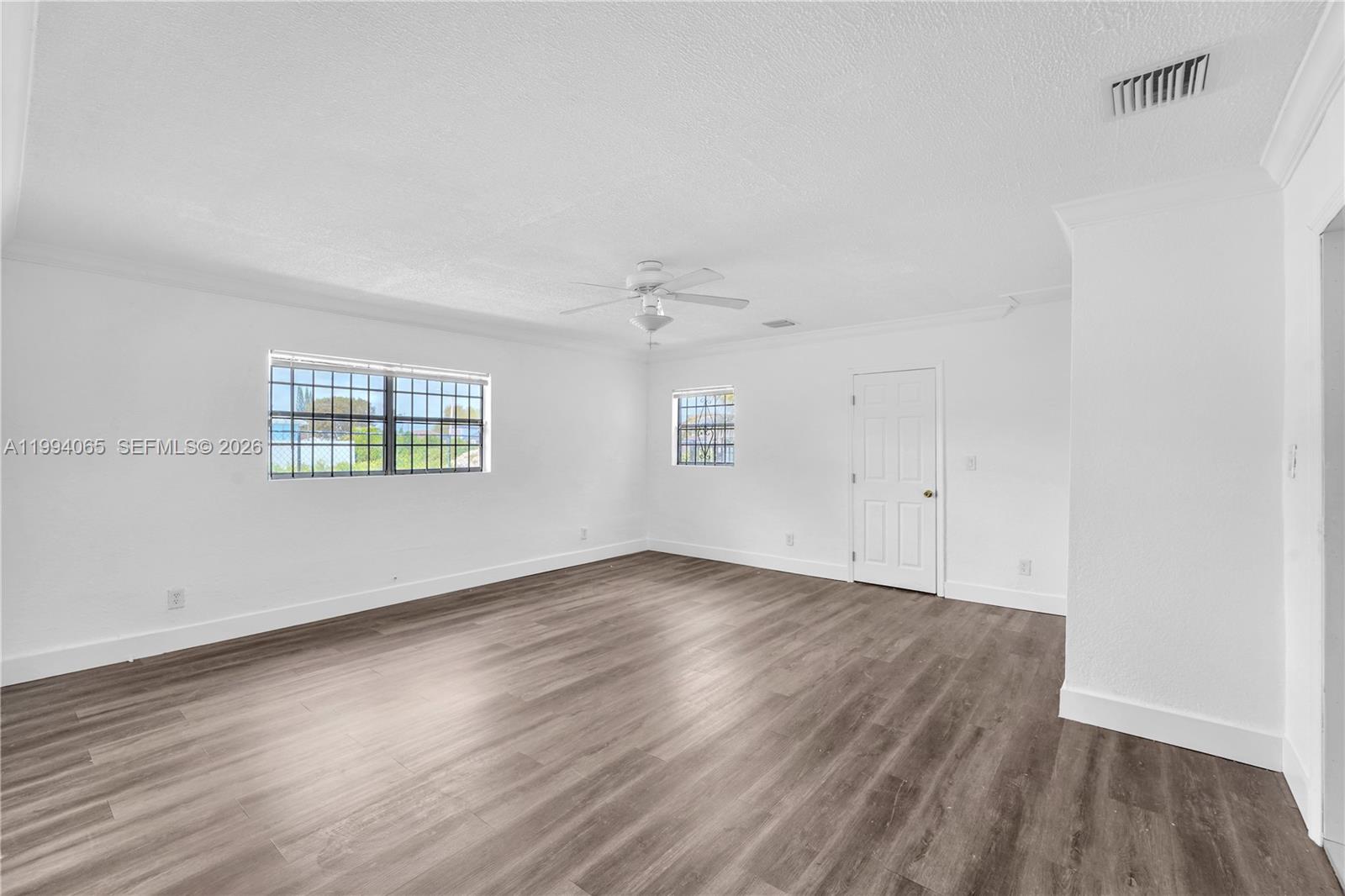 10960 Southwest 219th Street Miami, FL 33170 - Photo 13 of 22 an empty room with wooden floor and windows
