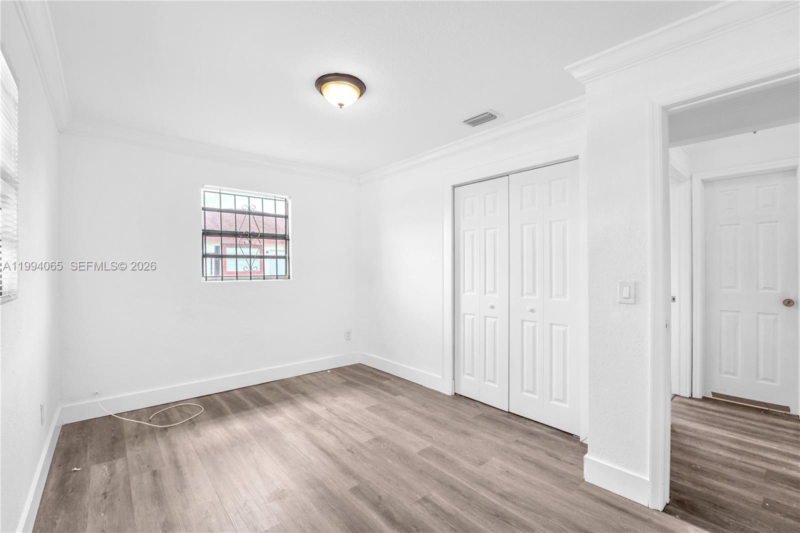 10960 Southwest 219th Street Miami, FL 33170 - Photo 17 of 22 an empty room with wooden floor and windows