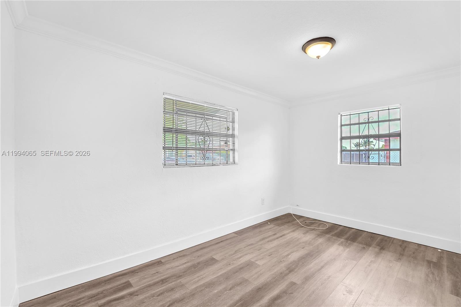 10960 Southwest 219th Street Miami, FL 33170 - Photo 18 of 22 an empty room with wooden floor and windows