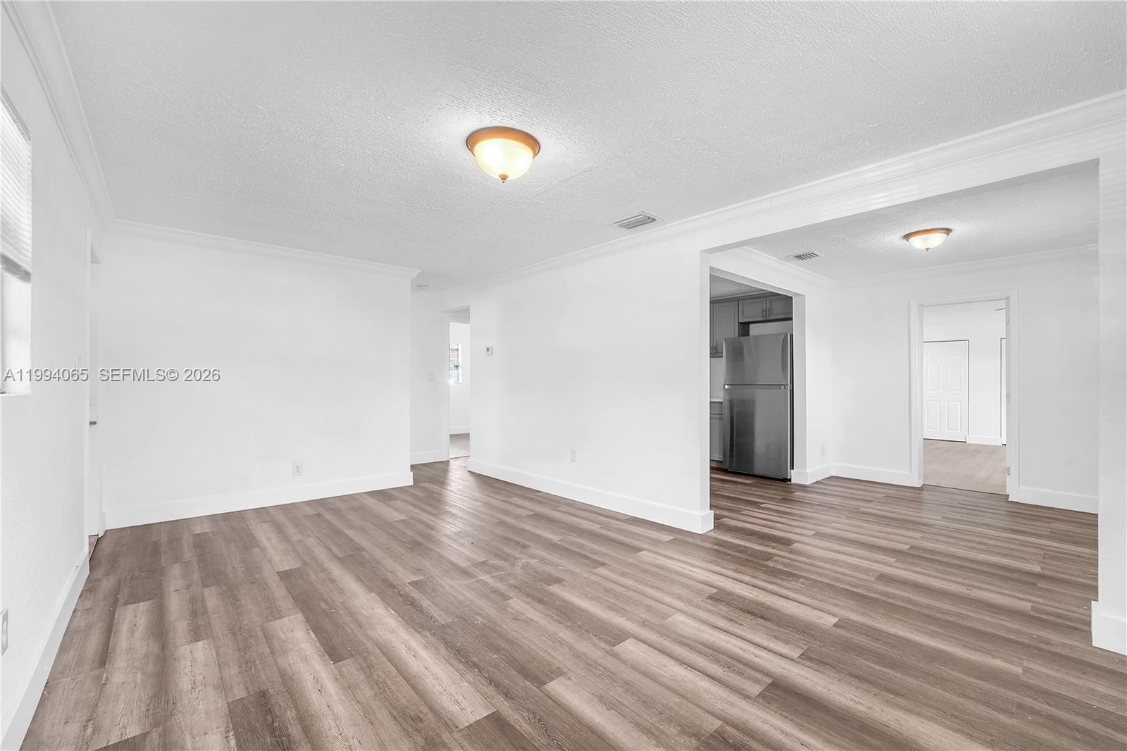 10960 Southwest 219th Street Miami, FL 33170 - Photo 6 of 22 a view of an empty room with wooden floor and a window