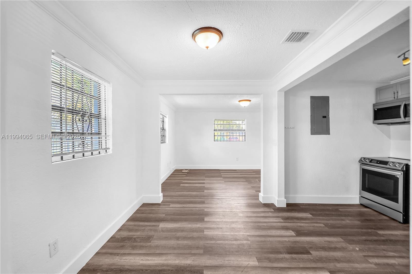 10960 Southwest 219th Street Miami, FL 33170 - Photo 8 of 22 a view of an empty room with window and wooden floor
