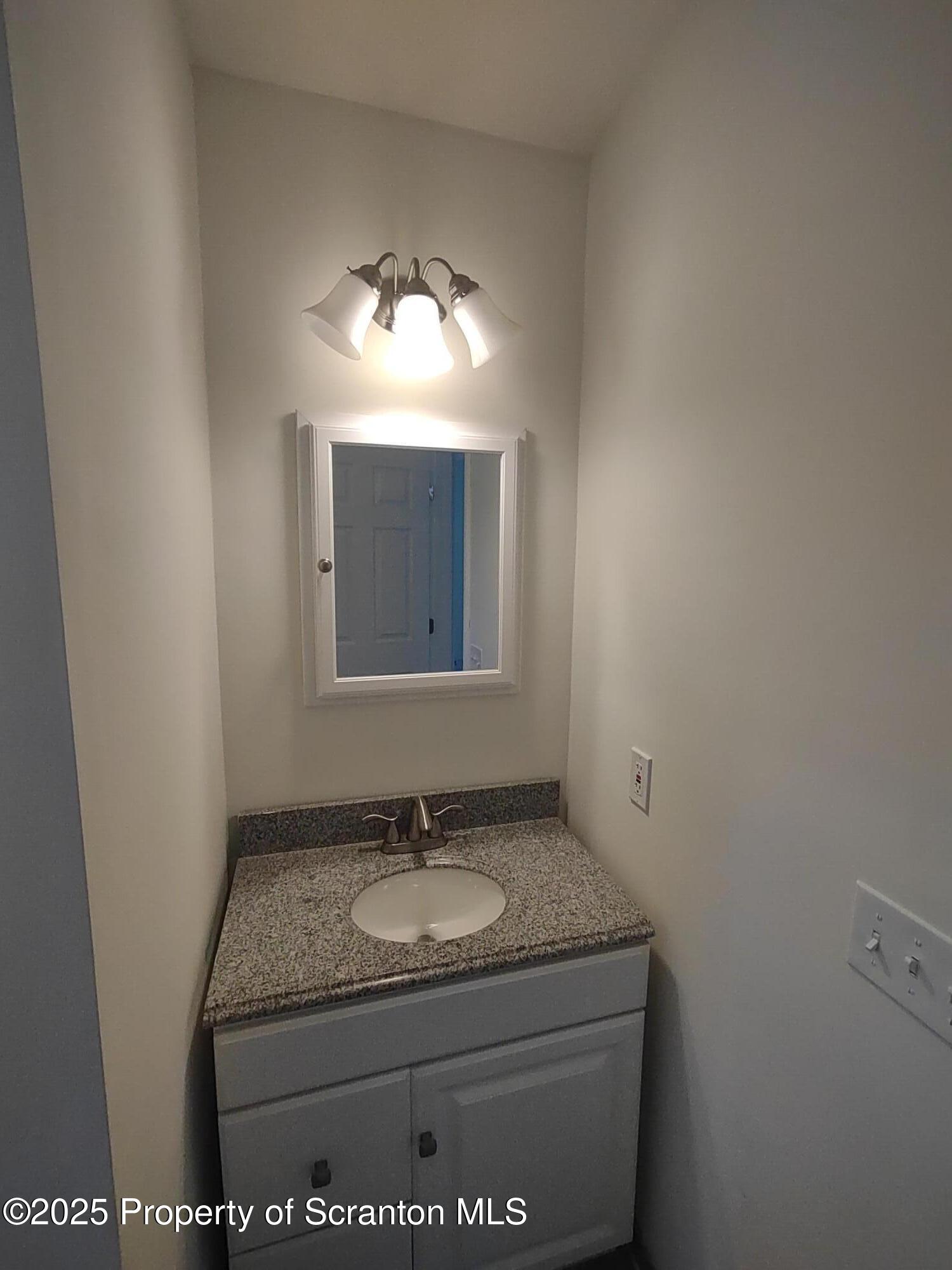1104 Filbert Street Archbald, PA 18403 - Photo 19 of 39 a bathroom with a granite countertop sink and a mirror