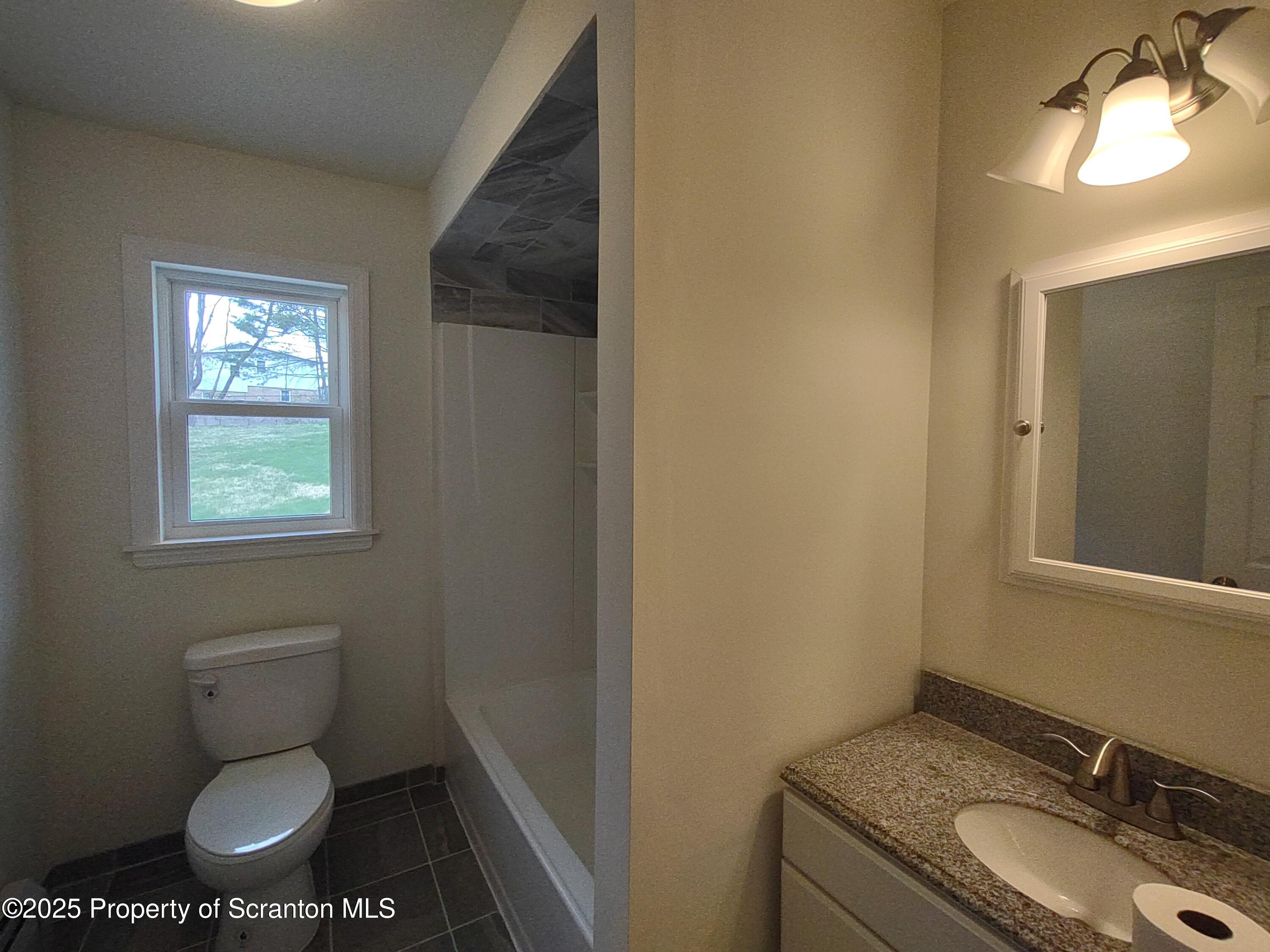 1104 Filbert Street Archbald, PA 18403 - Photo 23 of 39 a bathroom with a granite countertop toilet a sink and mirror