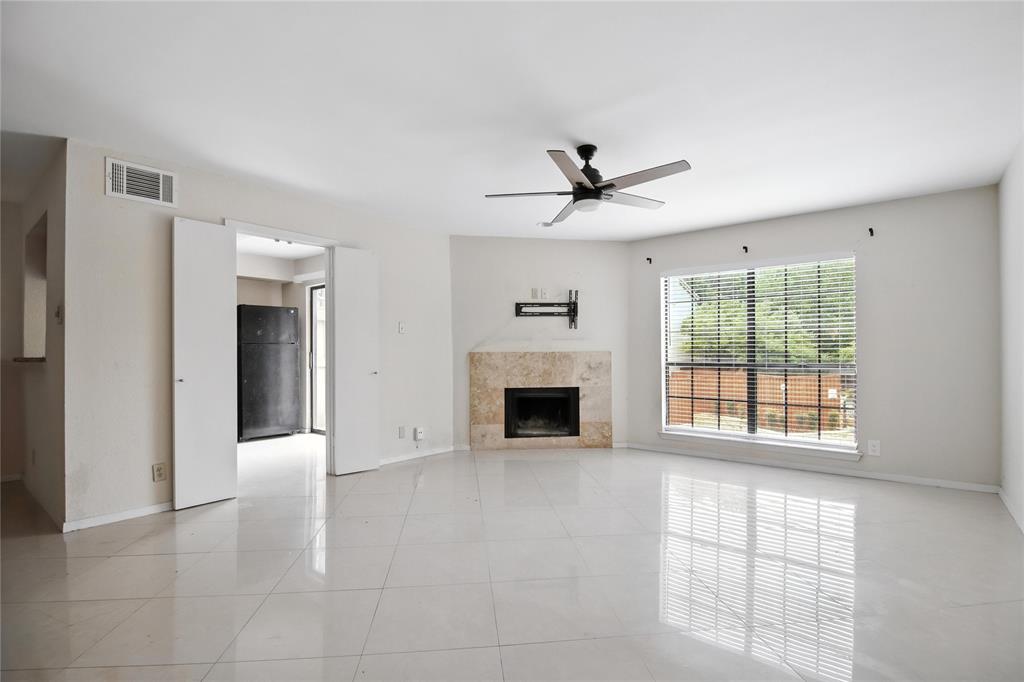 a view of an empty room with a fireplace and a window
