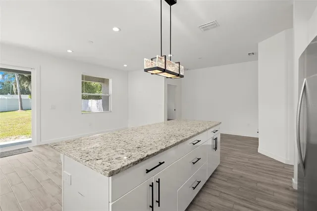 a bathroom with a granite countertop sink a light fixture and a fireplace