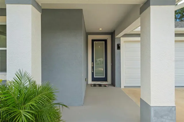 a view of front door with potted plants