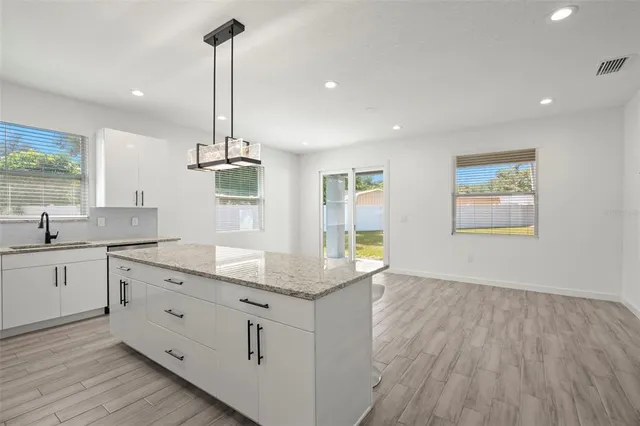 a kitchen with kitchen island a counter space a sink and appliances