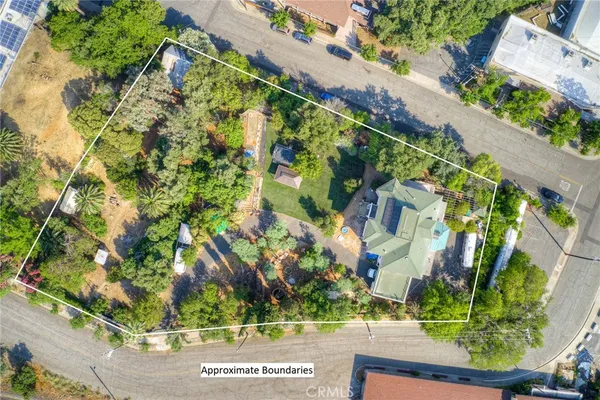 an aerial view of residential house with outdoor space and trees all around