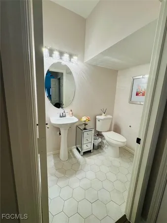 a bathroom with a toilet sink and mirror
