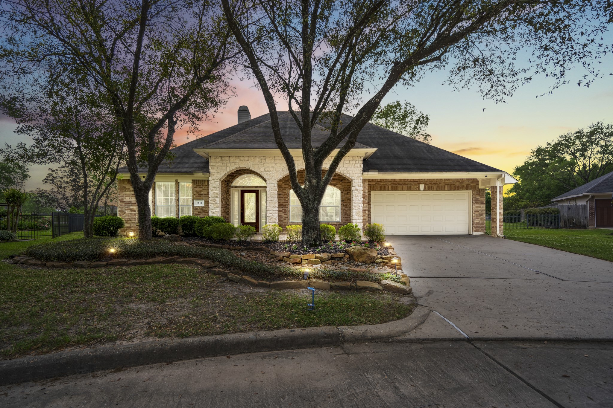 Beautiful curb appeal at 5810 Sequoia Trace Court surrounded by mature landscaping - the home sits on a cul-de-sac lot on the Windrose Golf Course.