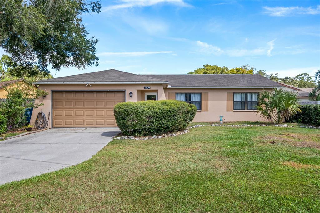 1400 Arbuckle Road Spring Hill, FL 34608 - Photo 1 of 1 a front view of a house with a yard and garage