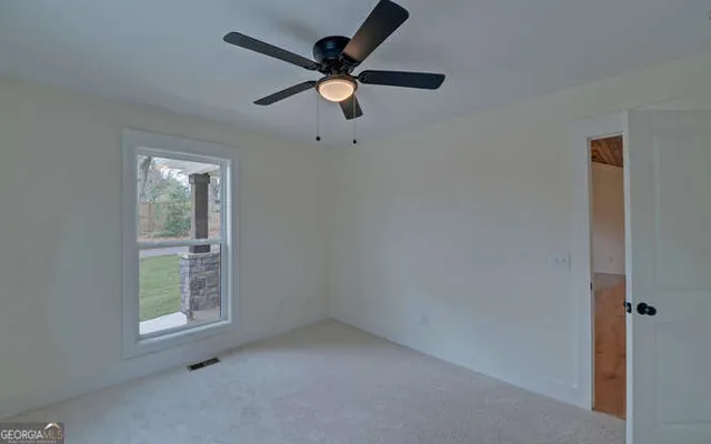 an empty room with closet and ceiling fan
