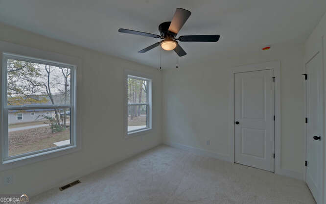 999 East Doyle Street Toccoa, GA 30577 - Photo 24 of 42 a view of empty room with wooden floor and fan