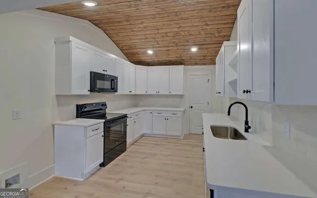 a kitchen with stainless steel appliances granite countertop a sink a stove and cabinets