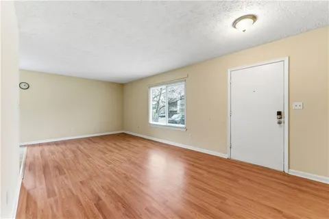an empty room with wooden floor and windows