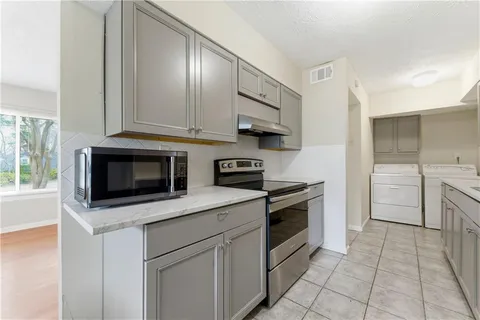 a kitchen with cabinets stainless steel appliances and sink