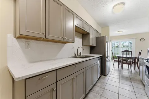 a kitchen with granite countertop a sink a stove and cabinets