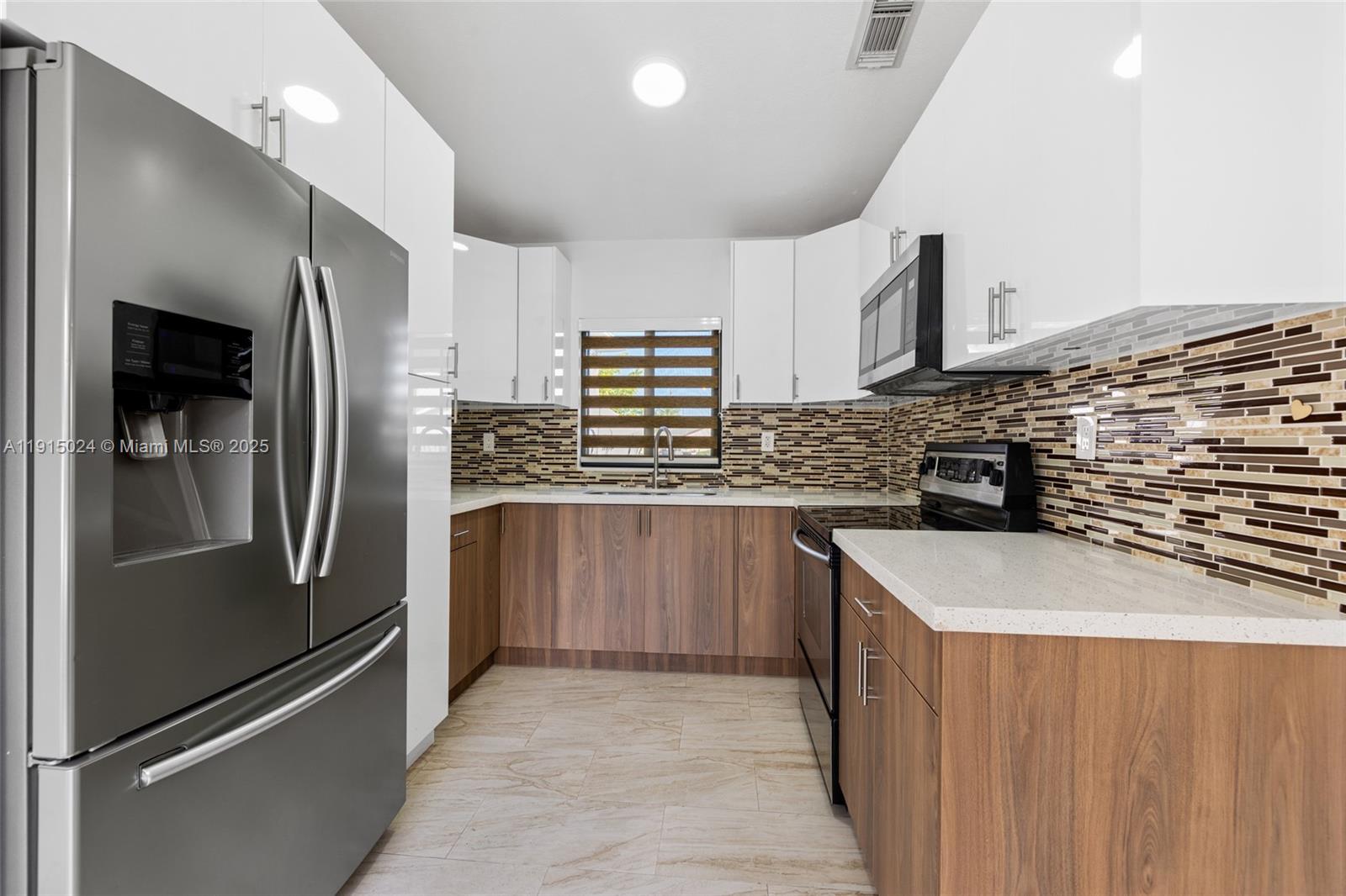 12740 Southwest 249th Terrace Homestead, FL 33032 - Photo 11 of 27 a kitchen with stainless steel appliances granite countertop a refrigerator and a sink