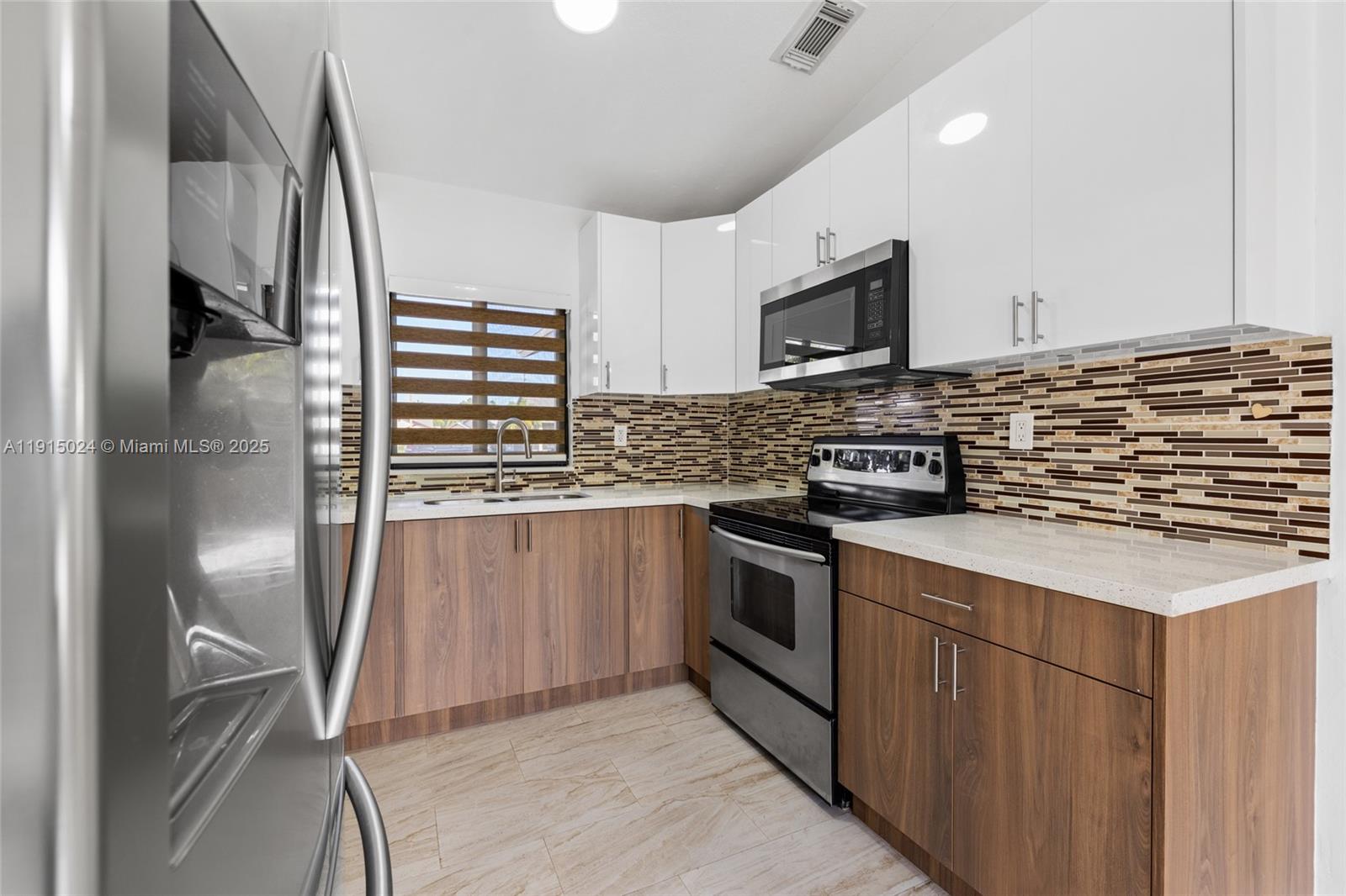 12740 Southwest 249th Terrace Homestead, FL 33032 - Photo 12 of 27 a kitchen with stainless steel appliances granite countertop a stove a sink and a refrigerator