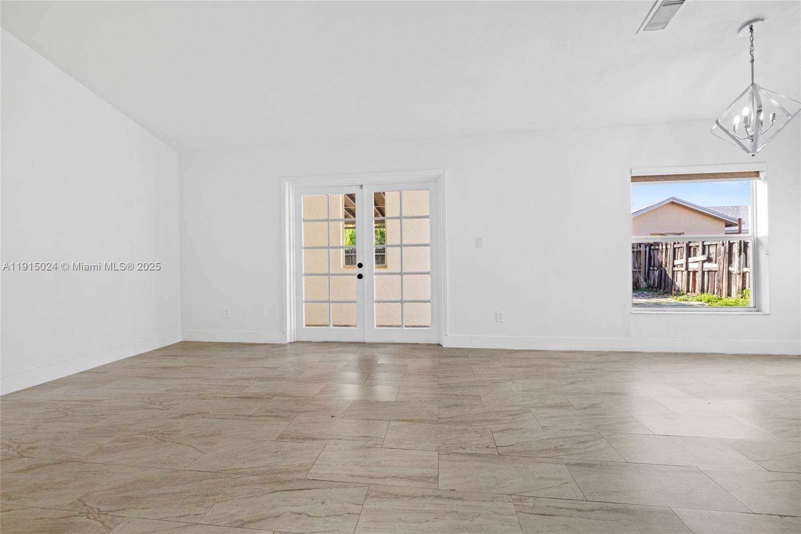12740 Southwest 249th Terrace Homestead, FL 33032 - Photo 7 of 27 a view of an empty room with window and wooden floor