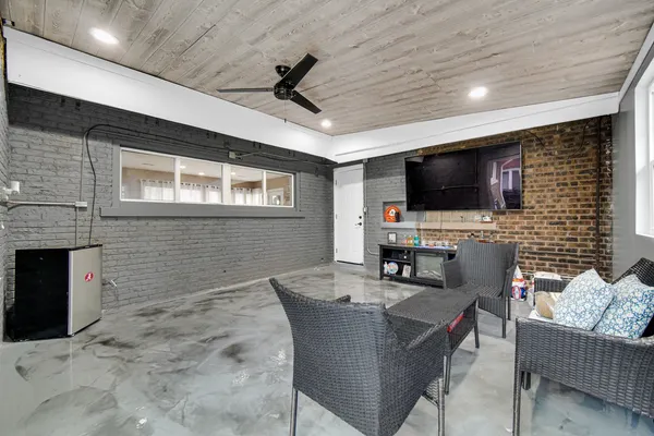a work room with furniture a flat screen tv and a fireplace
