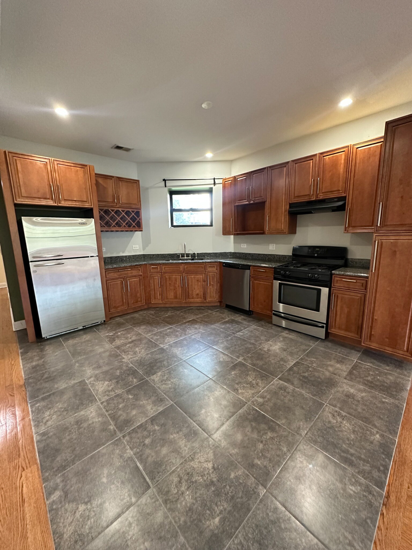 4336 South Indiana Avenue, Unit 1 Chicago, IL 60653 - Photo 2 of 15 a large kitchen with a large counter top and stainless steel appliances