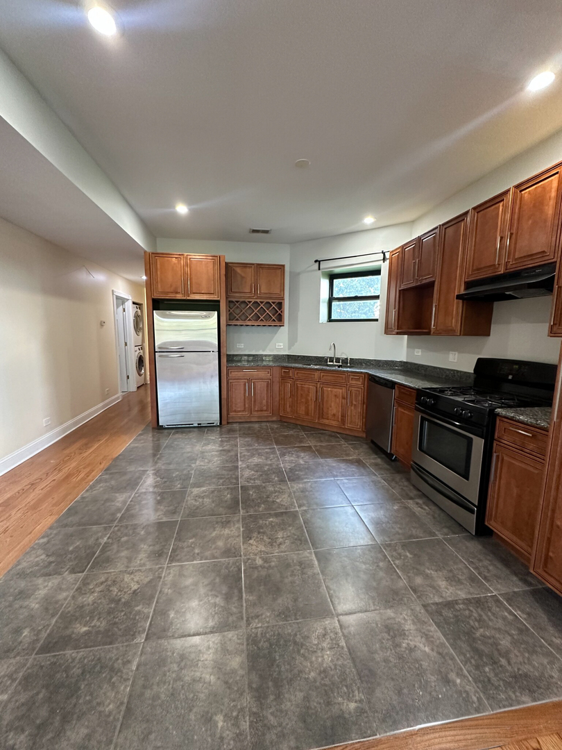 4336 South Indiana Avenue, Unit 1 Chicago, IL 60653 - Photo 3 of 15 a large kitchen with stainless steel appliances granite countertop a stove a sink dishwasher and a refrigerator