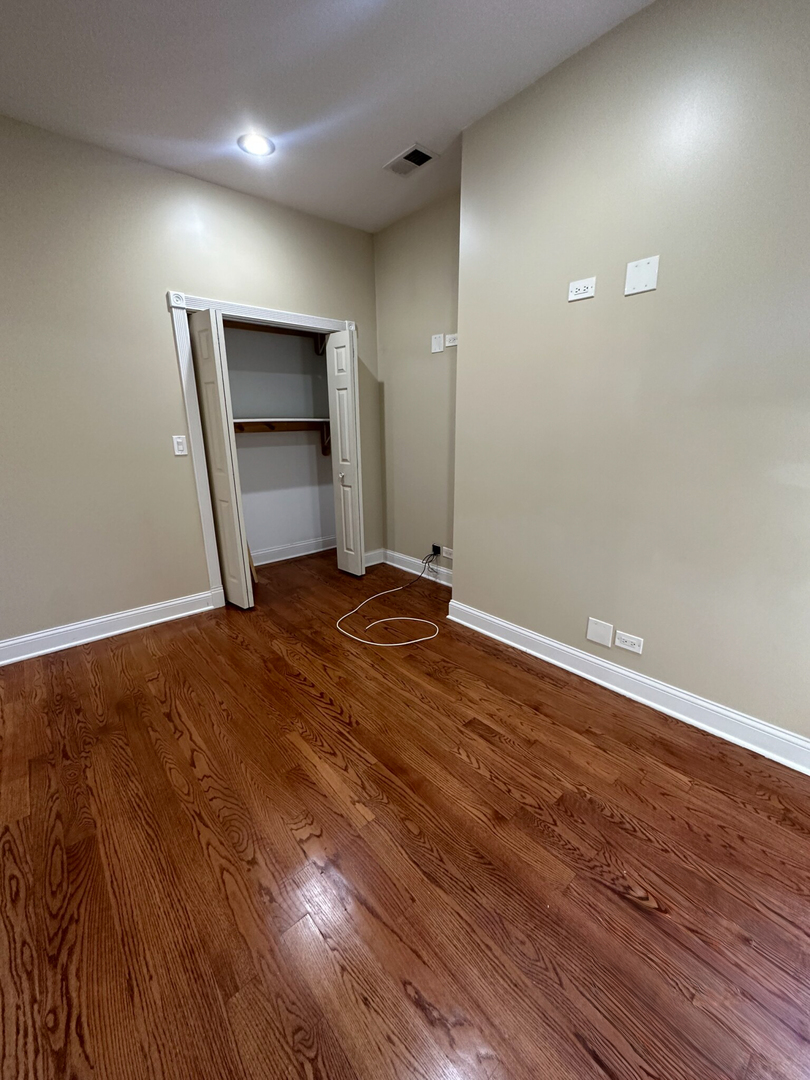 4336 South Indiana Avenue, Unit 1 Chicago, IL 60653 - Photo 10 of 15 an empty room with wooden floor and closet