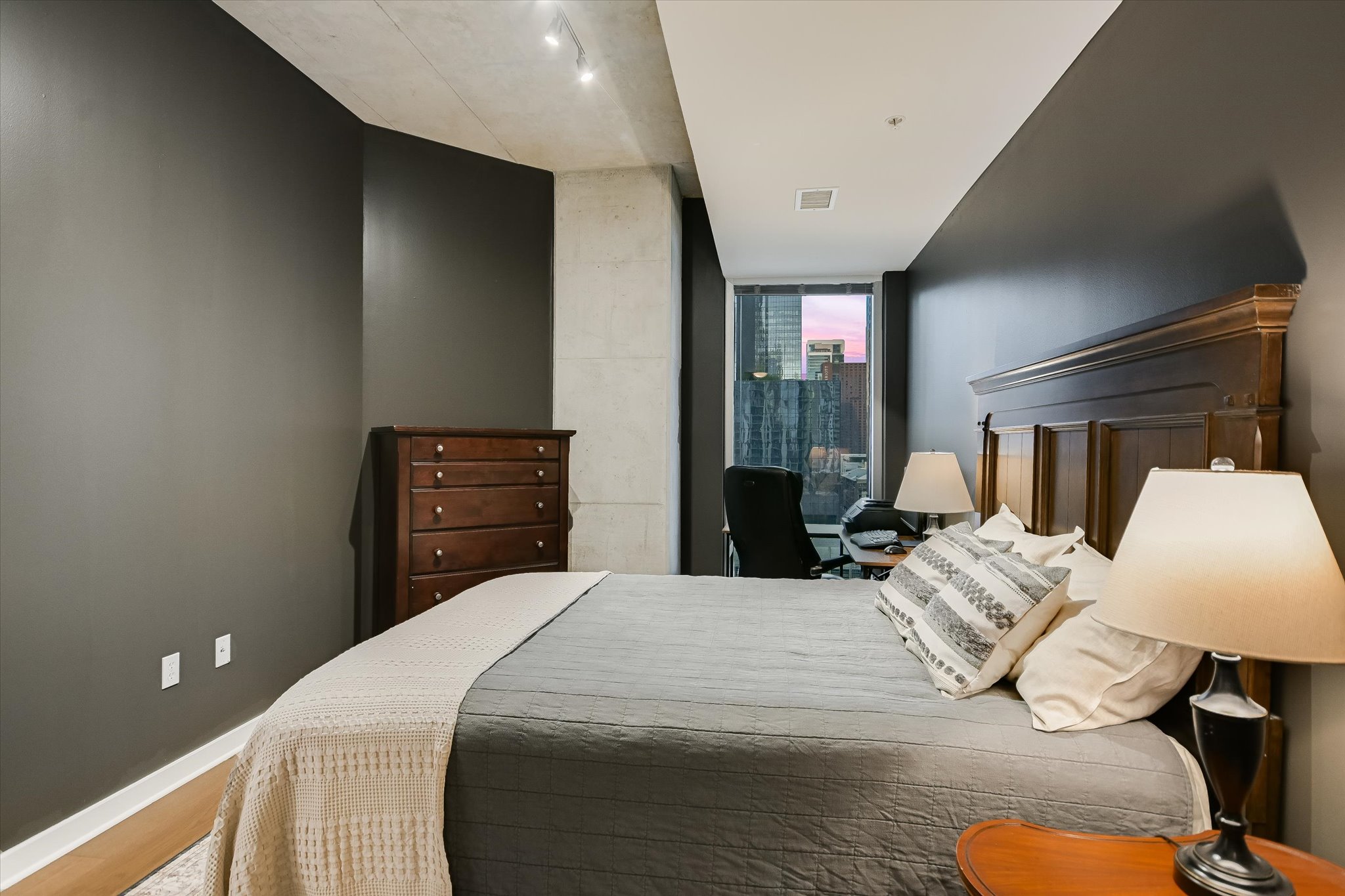 360 Nueces Street, Unit 1405 Austin, TX 78701 - Photo 20 of 40 a bedroom with a bed and a lamp