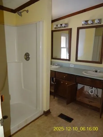 a bathroom with a granite countertop sink a mirror and a shower
