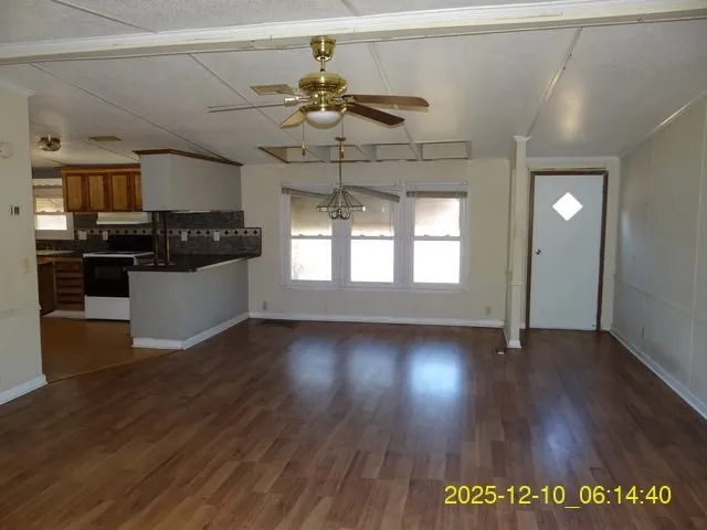 a view of a living room a kitchen and wooden floor