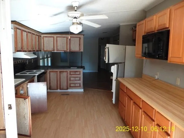 a kitchen with stainless steel appliances granite countertop a sink refrigerator stove and microwave