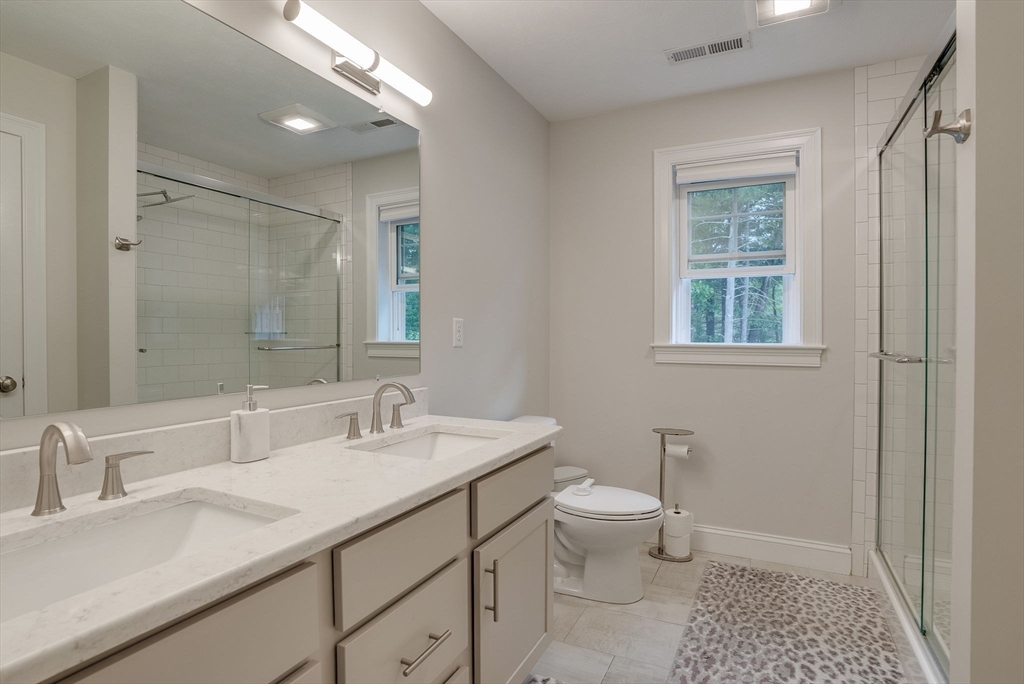 83 Littleton Road Ayer, MA 01432 - Photo 21 of 42 a bathroom with a granite countertop sink a toilet and a mirror