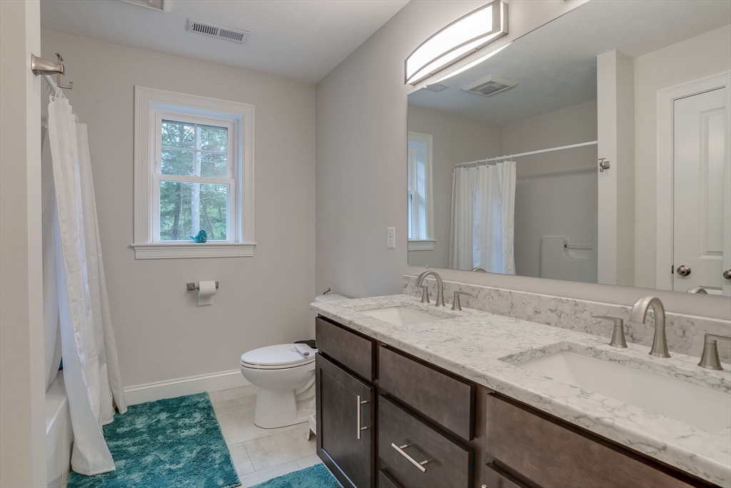 83 Littleton Road Ayer, MA 01432 - Photo 22 of 42 a bathroom with a granite countertop sink a toilet and a mirror