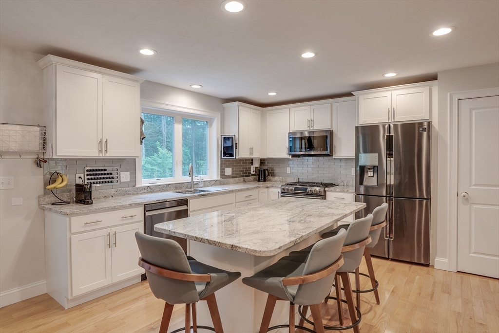 83 Littleton Road Ayer, MA 01432 - Photo 3 of 42 a kitchen with refrigerator a sink and chairs