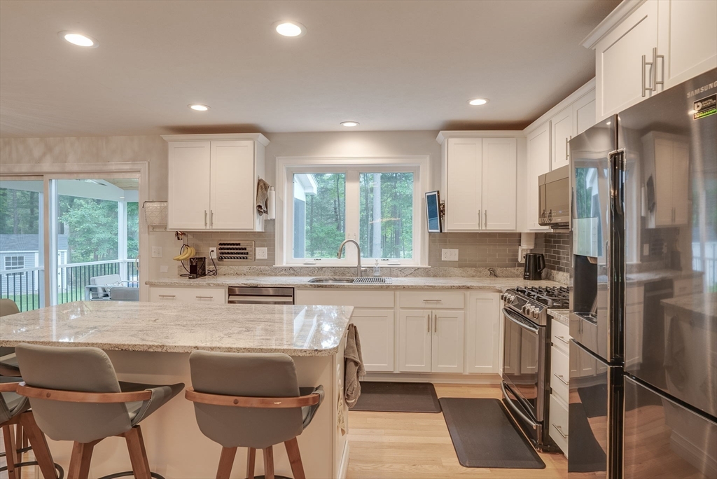 83 Littleton Road Ayer, MA 01432 - Photo 4 of 42 a kitchen with stainless steel appliances granite countertop a stove a sink a refrigerator white cabinets and a refrigerator