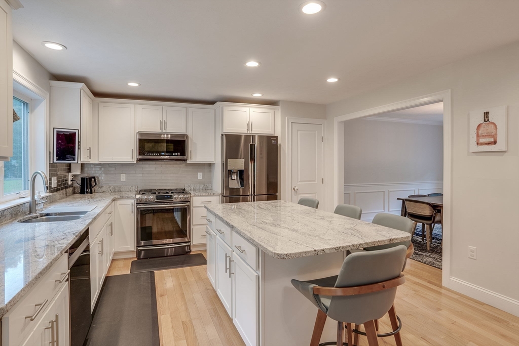 83 Littleton Road Ayer, MA 01432 - Photo 5 of 42 a kitchen with stainless steel appliances granite countertop a stove top oven a sink dishwasher a dining table and chairs with wooden floor
