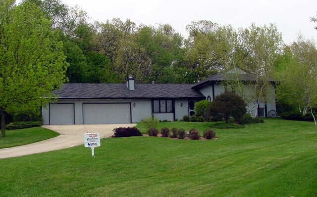 8248 Snaresbrook Road Roscoe, IL 61073 - Photo 1 of 1 a front view of a house with a garden and trees