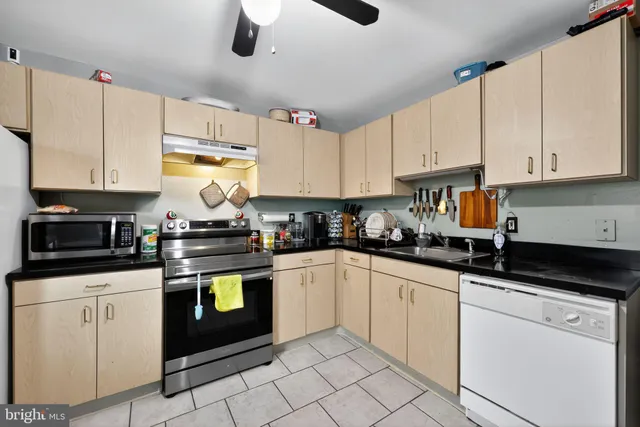 a kitchen with granite countertop white cabinets and white appliances