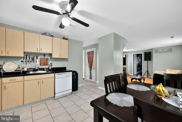 a kitchen with granite countertop lots of white cabinets a sink a stove and a window