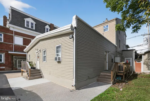 a view of a house with a door and wooden bench