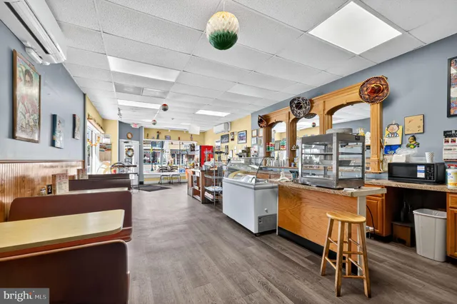 a very nice looking open dining room with kitchen island furniture a large window and stainless steel appliances