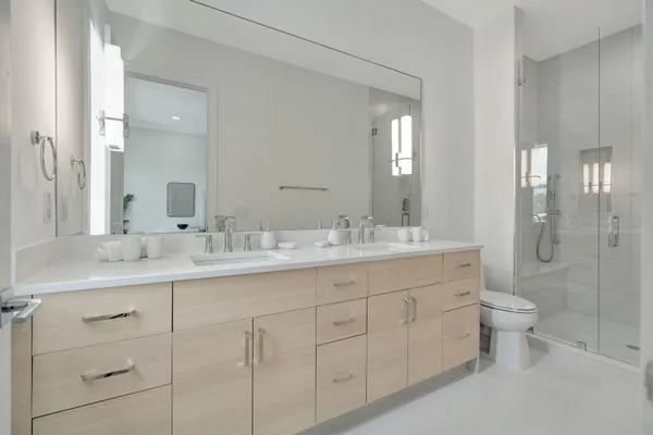 a bathroom with double vanity sink a toilet and a mirror