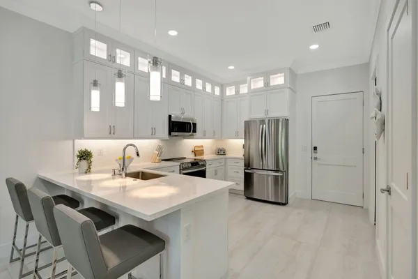a kitchen with a refrigerator a sink and chairs