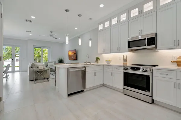 a kitchen with white cabinets and white appliances