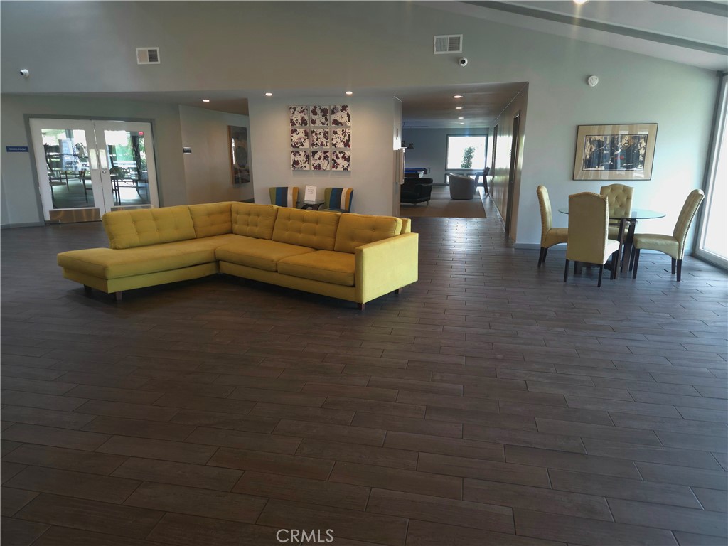 1550 Rimpau Avenue, Unit 20 Corona, CA 92881 - Photo 27 of 42 a living room with furniture and a dining table with kitchen view