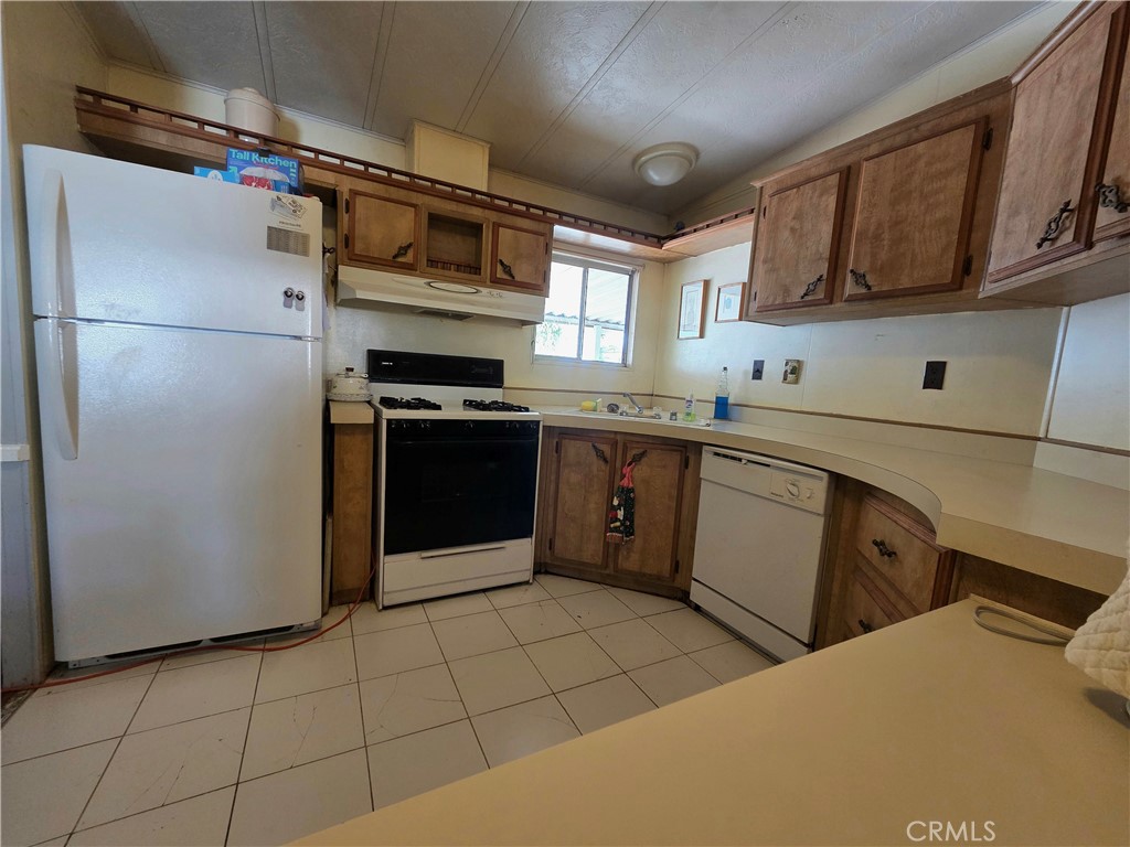 1550 Rimpau Avenue, Unit 20 Corona, CA 92881 - Photo 7 of 42 a kitchen with stainless steel appliances granite countertop a refrigerator sink and cabinets