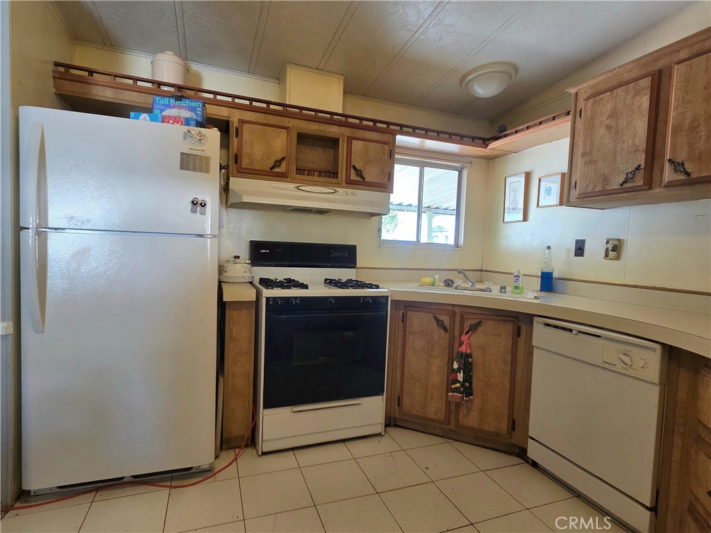 1550 Rimpau Avenue, Unit 20 Corona, CA 92881 - Photo 8 of 42 a kitchen with stainless steel appliances granite countertop a refrigerator and a sink