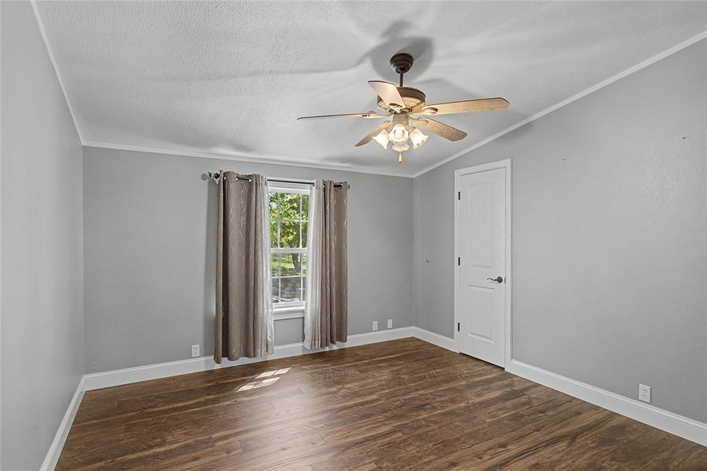 1701 Central Road Weatherford, TX 76088 - Photo 28 of 40 Bedroom featuring ornamental molding, a ceiling fan, dark wood-style flooring, and a textured ceiling.